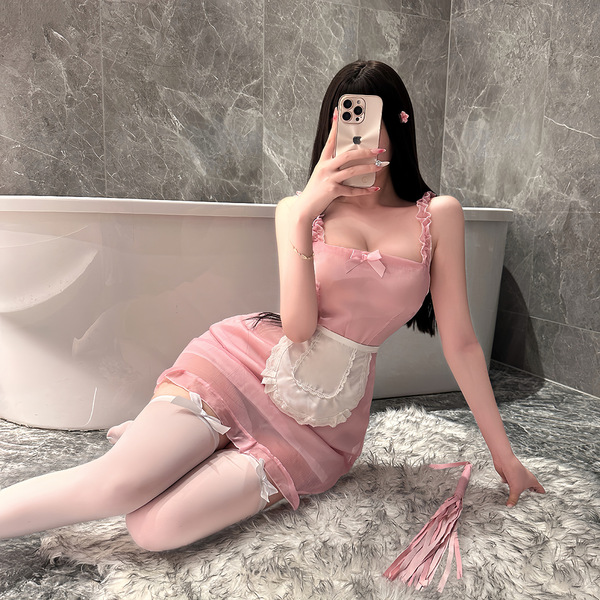 A woman poses in a pink maid costume, featuring a cute apron and stockings, sitting on a fluffy rug beside a bathtub. the out...