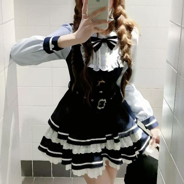 A woman poses in a mirror wearing a sweet lace doll collar bow dress, featuring a black and white design with ruffled layers ...
