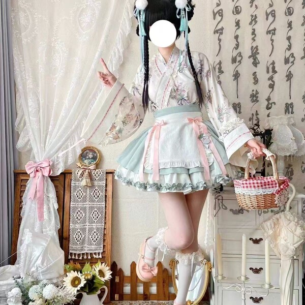 A woman models a sweet lolita maid dress set featuring a floral-patterned blouse, apron, and ruffled skirt, perfect for cospl...