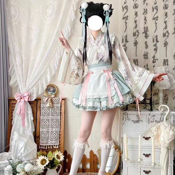 A woman models a sweet lolita maid dress set featuring a floral kimono, apron, and ruffled skirt, perfect for cosplay with bo...