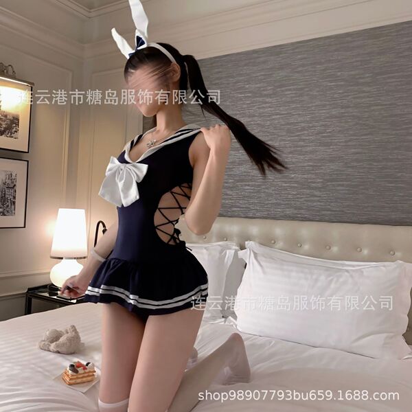 Woman wearing tangdao sensual lingerie set - navy sailor-style sleepwear with white bow, bunny ears, and lace-up sides in bed...