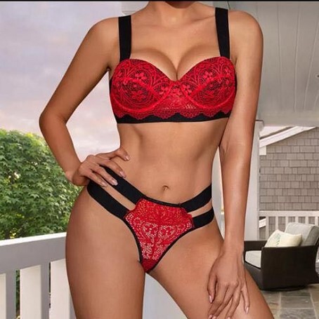 Woman modeling red lace push-up bodysuit and thong lingerie set on balcony.