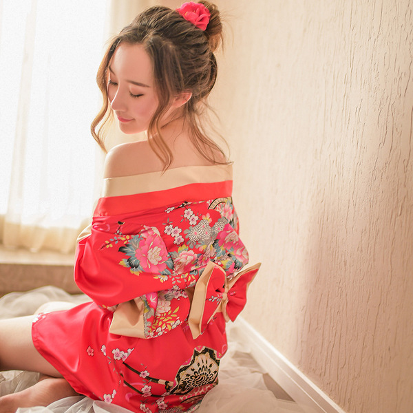 A woman elegantly poses wearing a vibrant red kimono-inspired bodysuit set, featuring floral patterns and delicate lace detai...