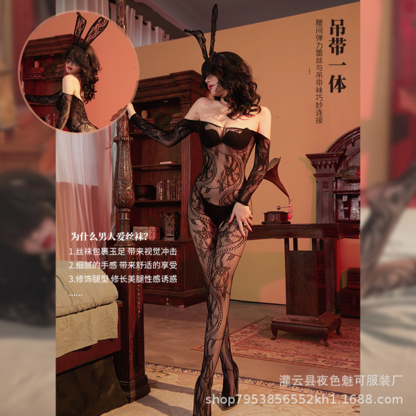 Woman modeling a black lace mesh bodysuit with bunny ears, featuring an open-crotch design and sheer tights in a vintage room...