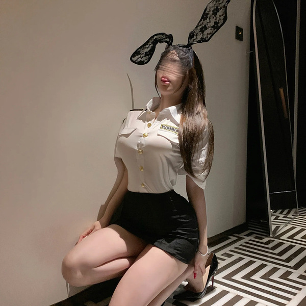 Sexy police-themed outfit featuring a white blouse with gold buttons, black mini skirt, and bunny ears headband, perfect for ...