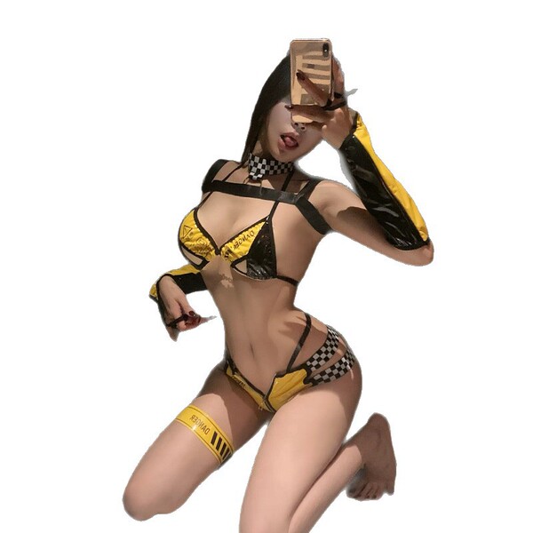 Woman in bold yellow and black latex-style pvc bodysuit, car model inspired two-piece ensemble, posing with phone.