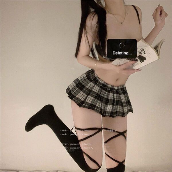 Woman wearing sexy jk-style lingerie set with sheer top, plaid skirt, and thigh-high stockings, holding a book.