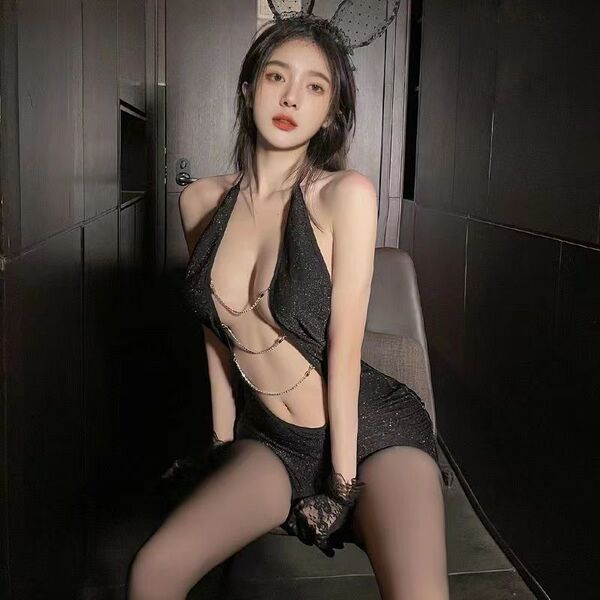 Woman wearing a sexy secretary costume with deep v-neck, backless design, and bodycon fit for nightclub or role play.
