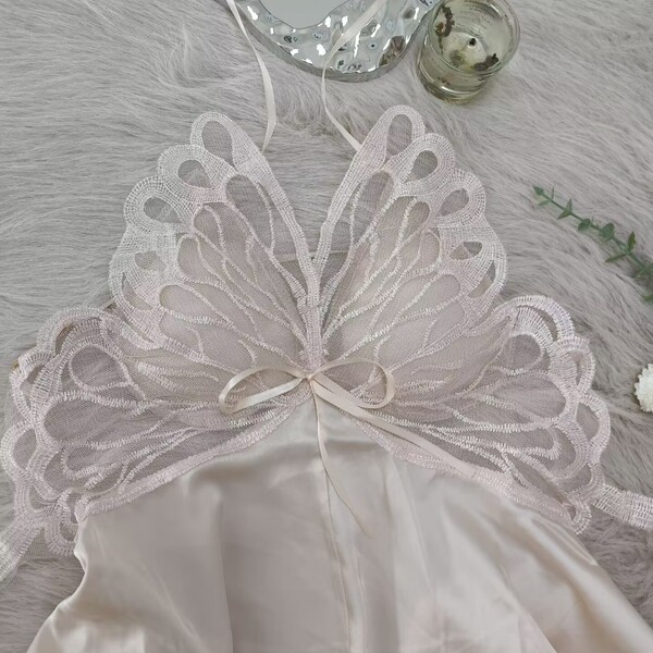 Womens summer ice silk sleep dress with bow & backless cutout - sexy lounge set displayed on a soft, fluffy surface.