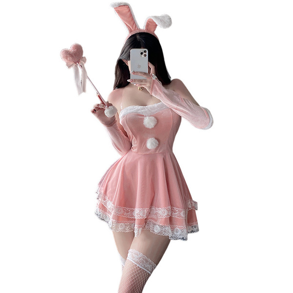 A woman poses in a pink bunny-themed costume, featuring rabbit ears, a lace-trimmed dress, and stockings, perfect for festive...
