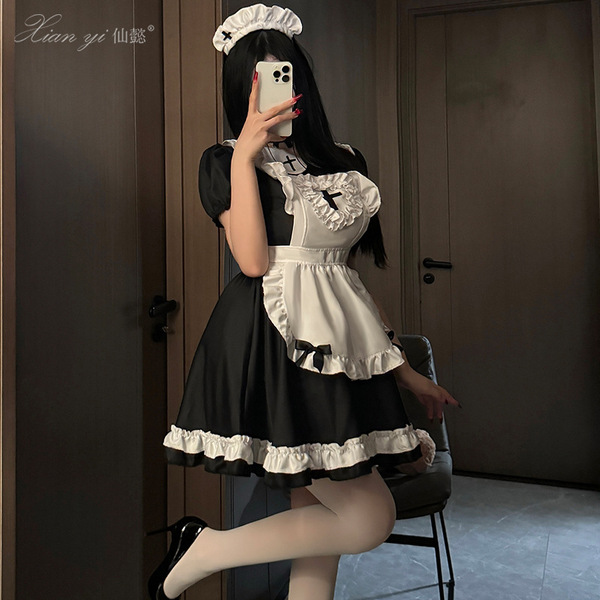 A woman poses in a black and white maid costume, featuring ruffled details and a frilly apron, perfect for anime cosplay or r...
