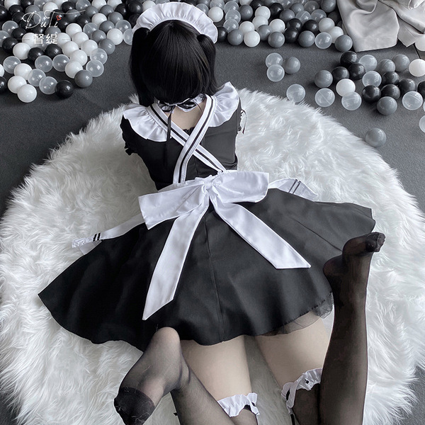 A person wearing a black maid costume with white apron and bow tie, sitting on a fluffy rug surrounded by balls. perfect for ...