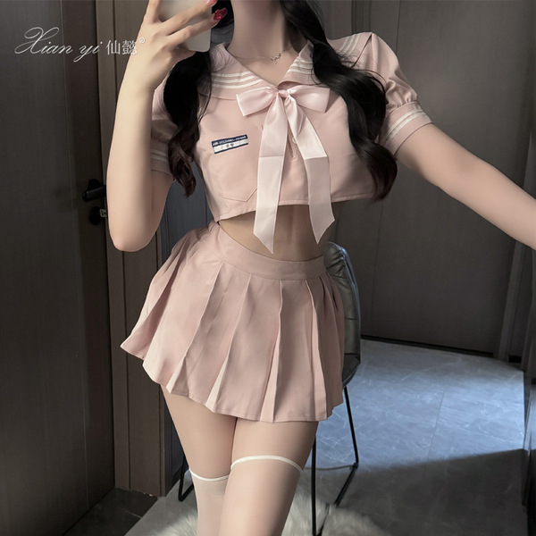 A woman models a peach-colored schoolgirl-style skirt with a sailor top, featuring a bow detail and pleated design, perfect f...