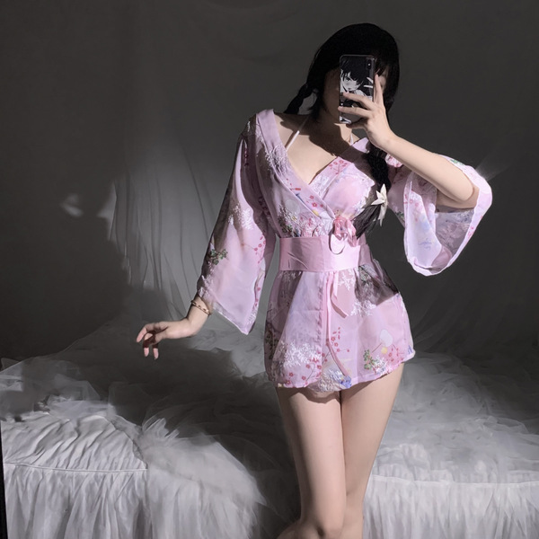 A woman poses in a japanese kimono-inspired lace sleepwear set, featuring sheer details and floral patterns, perfect for a se...