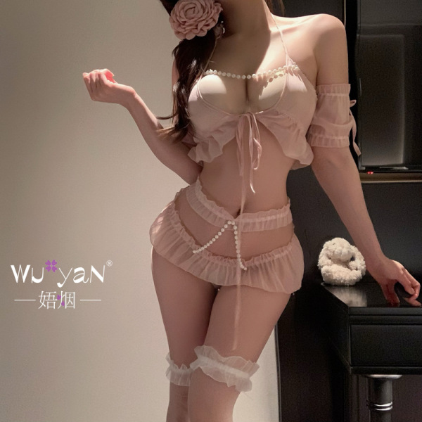 Woman modeling pink yan yan tiao seductive maid costume with pearl accents, ruffles, and garters for romantic role play.
