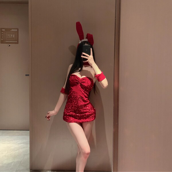 A woman poses in a red halter bunny costume, featuring a sparkly bodysuit with a bow headband, perfect for cosplay or live st...