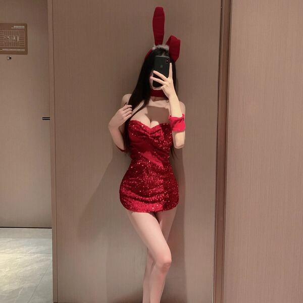 A woman poses in a red halter bunny costume with sparkly sequins, perfect for cosplay or live streaming events.