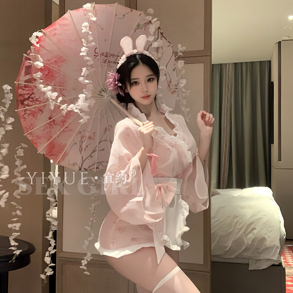 A woman poses elegantly holding a delicate parasol, wearing a soft pink japanese kimono-inspired costume with bunny ears. per...