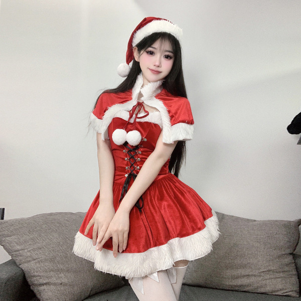 A woman wears a festive red dress with white fur trim, featuring a santa hat and bow tie, perfect for holiday celebrations.