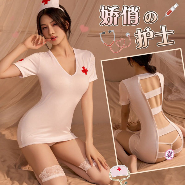 Woman modeling white nurse costume with open-crotch design and backless skirt, featuring lace garters and red cross accents.