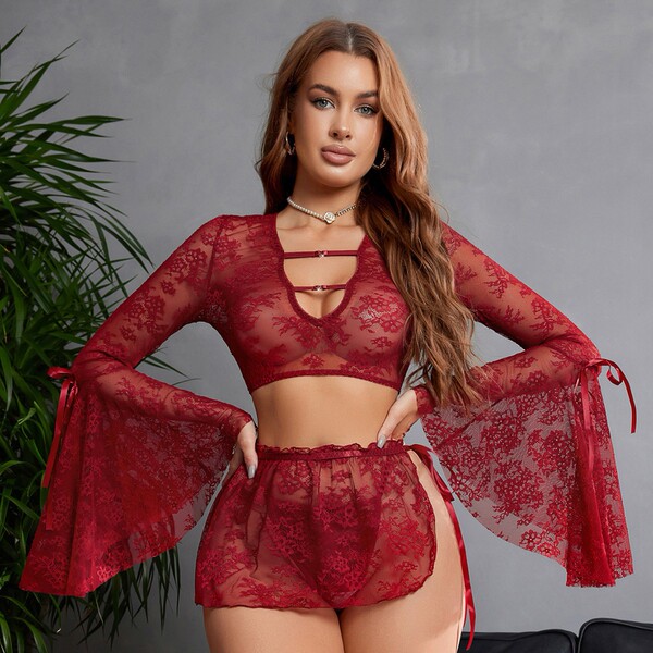 Woman modeling red lace lingerie set with deep v, flared sleeves, and detachable ties.