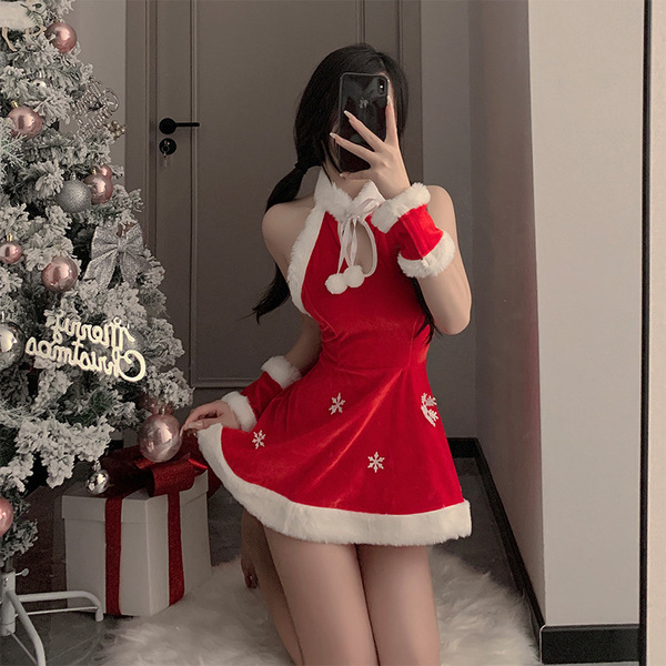 A woman poses with a christmas tree, wearing a red velvet christmas cosplay lingerie set featuring a sexy nightgown and festi...