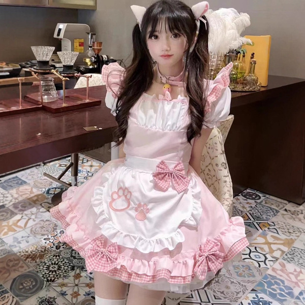 A cute girl wearing a pink japanese maid cosplay dress with cat ears and paw prints, perfect for a soft girl aesthetic.