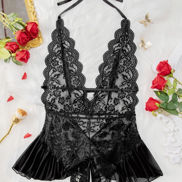 Luxury black lace bodysuit with sheer panels and ruffled hem, styled on white fur with red roses.