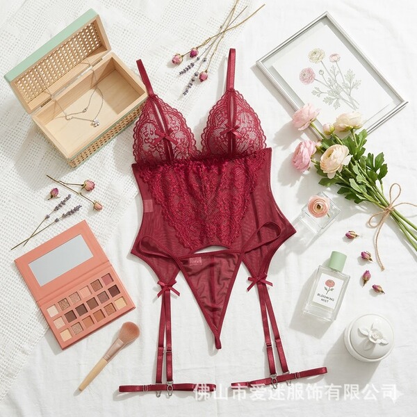 Red lace cami set with garter straps, styled as an elegant erotic bodysuit for women, surrounded by beauty accessories and fl...