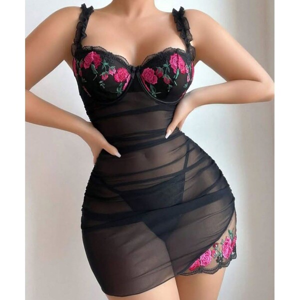 Woman wearing black lace sheer sleepwear set with pink rose embroidery, featuring mesh nightgown and matching bra.