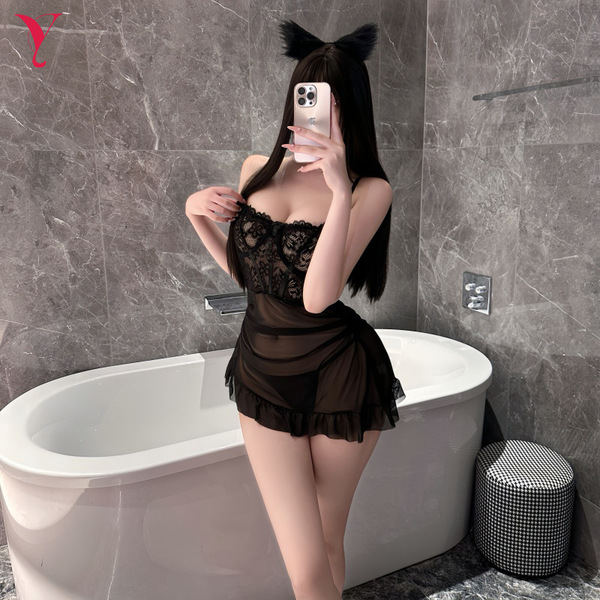 A woman poses in a bathroom wearing a black lace dress with sheer fabric, featuring cat ears and a ruffled hem. the design hi...