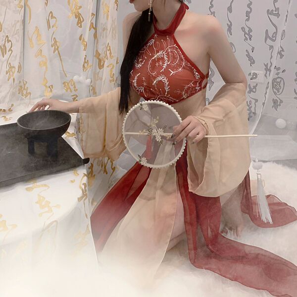 A woman elegantly poses with a traditional fan, wearing a luxurious red and beige costume inspired by classic attire. the des...