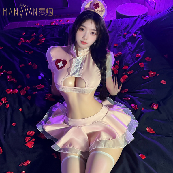 Woman in pure temptation nurse costume with lace lingerie and flirty petticoat skirt, posing on bed with rose petals.