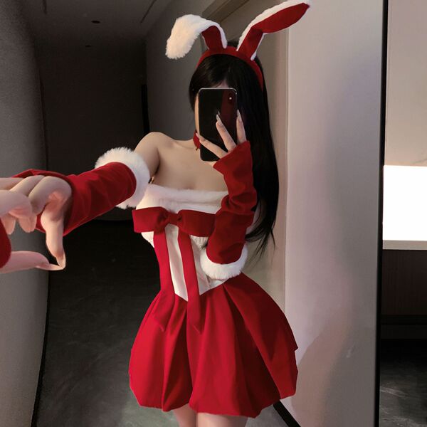 Woman in red and white christmas bunny costume with fluffy trim, bow, and ears, posing playfully for mirror selfie.