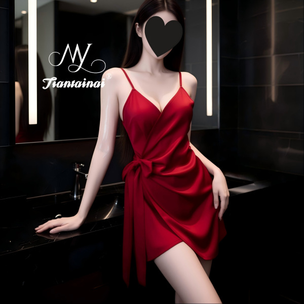 Woman in red satin cami dress with waist tie, posing by sink—elegant, curvy-friendly lingerie for seductive nights.