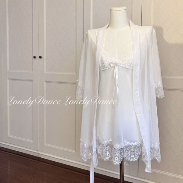 White lace sleepwear set with sheer mesh cami, shorts, and matching robe on mannequin.
