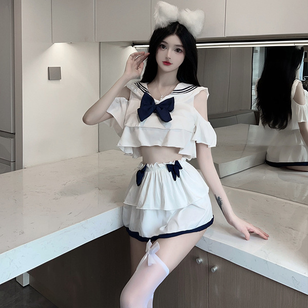 A stylish young woman poses confidently wearing a cute sailor-themed cosplay outfit. the ensemble features a white crop top w...