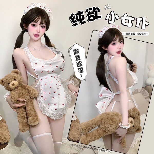 A woman poses in a white lace maid outfit with red cherry patterns, holding a teddy bear. the design features playful element...