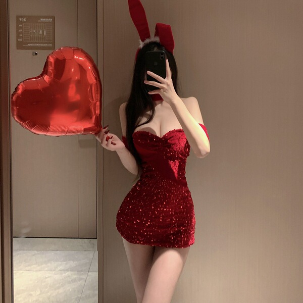A woman poses in a red halter bunny costume with sparkling sequins, holding a heart-shaped balloon. perfect for cosplay or li...
