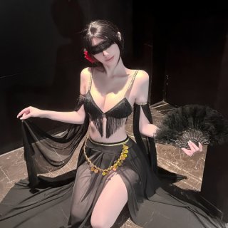 Woman in black fringed lingerie set with gold accents, holding feather fan and sheer fabric, exuding elegance and sensuality.