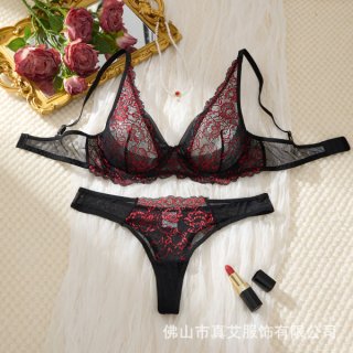 Elegant black and red sheer lace bra set with push-up support, styled on soft white fabric with roses and lipstick.
