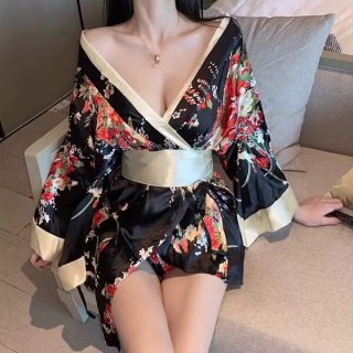A woman wears a black floral japanese kimono-style lingerie with butterfly print, featuring a deep v-neck and flowing sleeves...