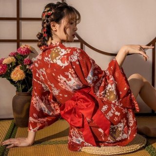 A woman poses elegantly wearing a vibrant red japanese kimono-style sleepwear set, featuring floral patterns and a large bow ...