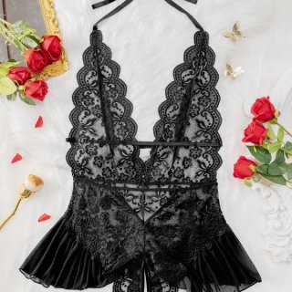 Luxury black lace bodysuit with sheer panels and ruffled hem, styled on white fur with red roses.