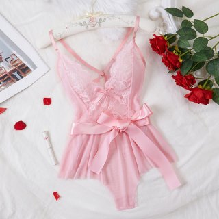 Pink lace sheer bodysuit with bow, displayed on hanger with roses and petals.