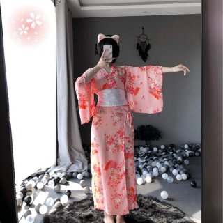 A woman poses in a mirror wearing a pink floral japanese kimono-style cat lingerie set, featuring long sheer satin sleepwear ...