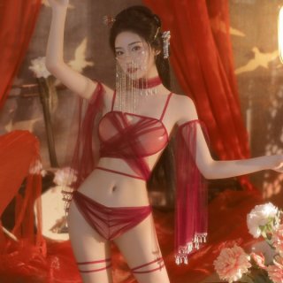 Woman wearing manny qing red sheer lace bralette set with hanfu-inspired details, posing in a warm, floral-lit setting.