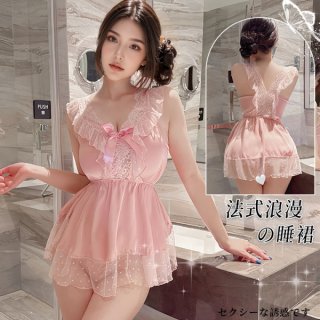 Woman wearing pink pure & seductive lace sleep dress with ruffles, bow, and sheer overlay in a marble bathroom setting.