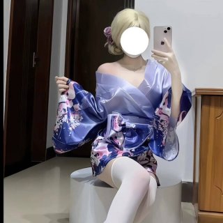 A woman poses in a luxurious purple kimono-style outfit adorned with floral patterns, featuring a deep v neckline and flowing...