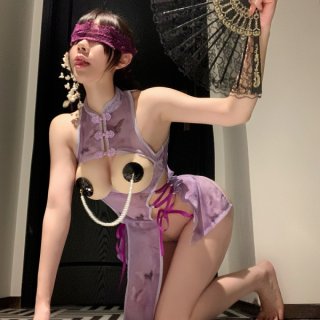 Woman in purple silk cheongsam lingerie with open-crotch design, lace fan, and blindfold for romantic date night.